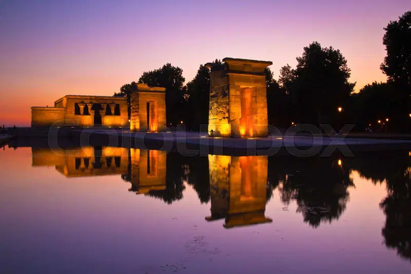 The Temple of Debod reflecting on calm waters at sunset.